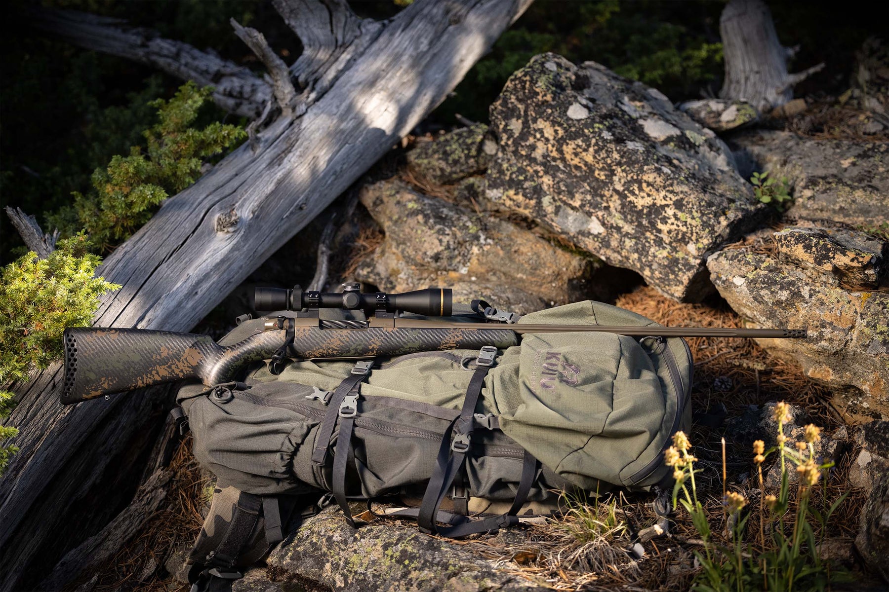 IMAGE OF STOCK ON BACKPACK NEXT TO ROCKS. - INLETS FOR REMINGTON 700, WEATHERBY MARK V AND WEATHERBY VANGUARD / HOWA 1500